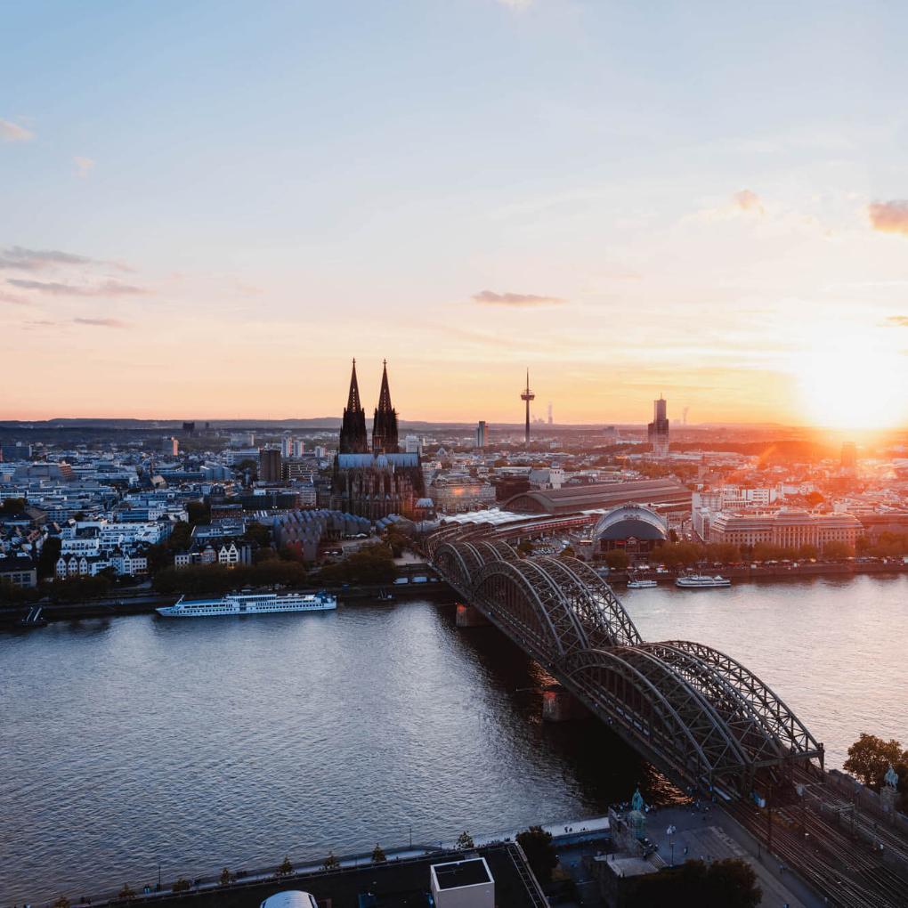 Sonnenuntergang fotografiert von der linken Rheinseite. Man sieht den Kölner Dom und die Hohenzollernbrücke.