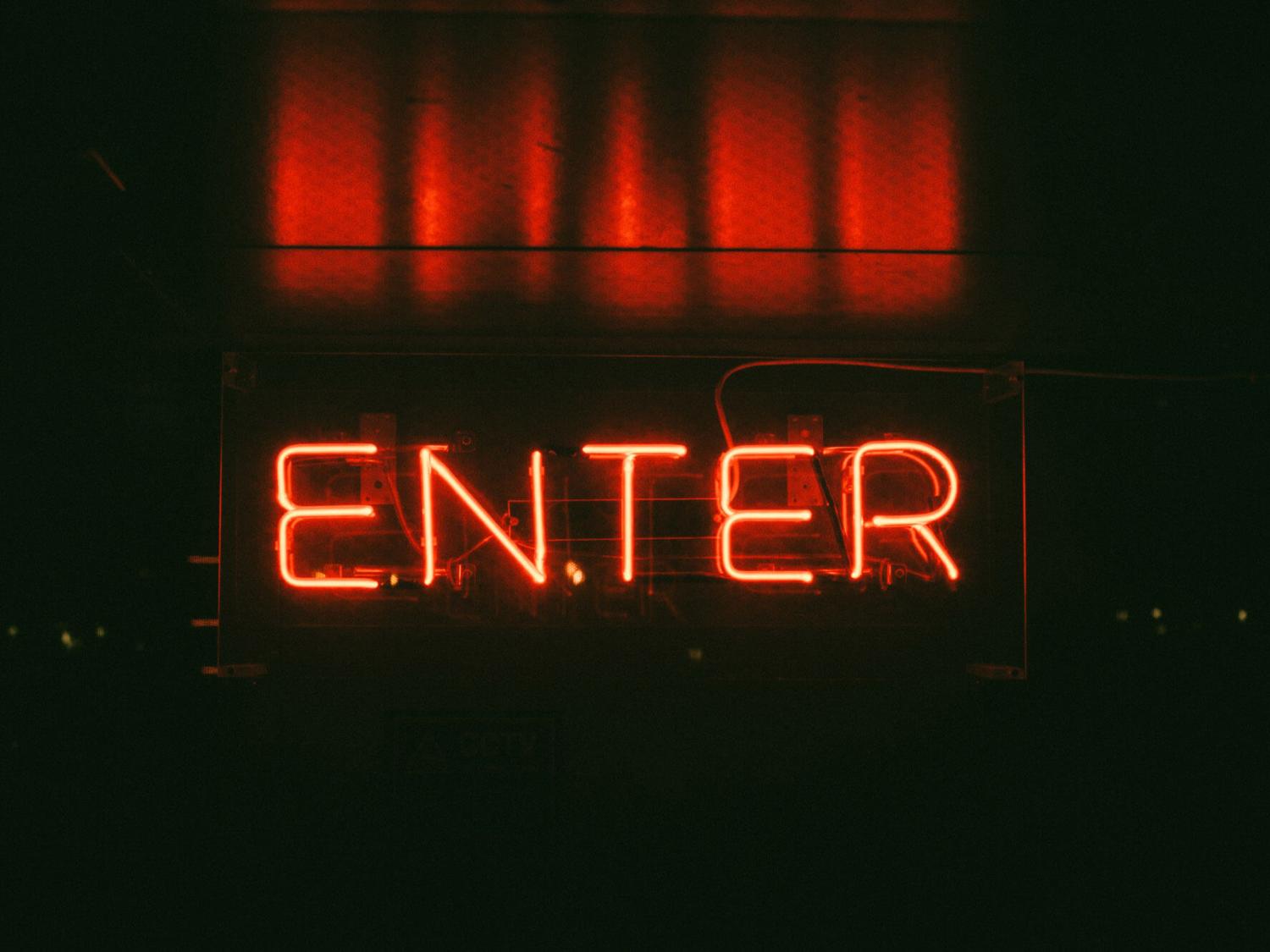 Dunkler Hintergrund mit rotem Schriftzug 'Enter' als Neonlicht